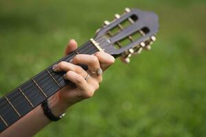 Nahansicht von Hände Putten ein Akkord auf das Gitarre foto