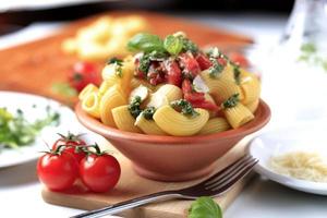 Makkaroni mit Kapern, zerdrückten Tomaten und Pesto foto