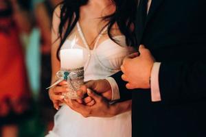 Das Brautpaar hielt sich mit einer Kerze an den Händen foto