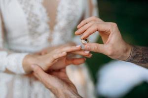 Bräutigam setzt Braut auf Ehering foto