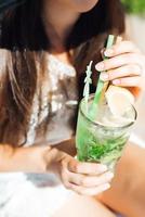 Mädchen ist ein Getränk-Fruchtalkohol-Cocktail auf der Basis von Limette, Minze, Orange, Soda foto