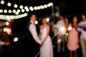 Wunderkerzen bei der Hochzeit, ein paar Brautpaare im Hintergrund foto