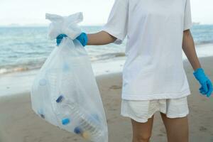 speichern Ozean. Freiwillige wählen oben Müll Müll beim das Strand und Plastik Flaschen sind schwierig zersetzen verhindern Schaden Wasser- Leben. Erde, Umfeld, Begrünung Planet, reduzieren global Erwärmen, speichern Welt foto