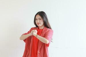 Porträt von schön asiatisch Frau tragen rot Outfit mit Faust gestikulieren mit ernst Ausdruck foto