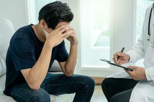 Mann mit mental Gesundheit Probleme ist Beratung. Psychiater ist Aufzeichnung das Patienten Bedingung zum Behandlung. Ermutigung, Liebe und Familie Problem, bipolar , Depression geduldig, schützen Selbstmord foto