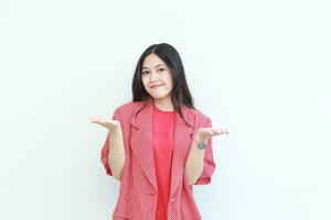 Porträt von schön asiatisch Frau tragen rot Outfit mit Hand Geste präsentieren etwas oder Kopieren Raum foto
