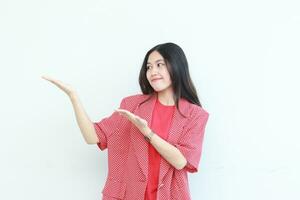Porträt von schön asiatisch Frau tragen rot Outfit zeigen zu das Seite zum Kopieren Raum foto