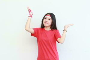 Porträt von schön asiatisch Frau tragen rot Outfit feiern Indonesien Unabhängigkeit Tag zeigen oben zum Kopieren Raum foto