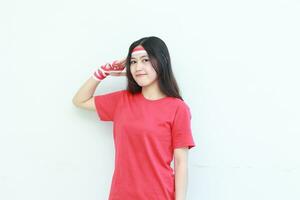 Porträt von schön asiatisch Frau tragen rot Outfit feiern Indonesien Unabhängigkeit Tag mit respektvoll Geste foto