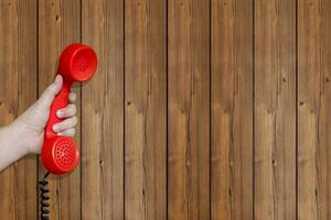 rot Telefon Headset mit hölzern Hintergrund foto