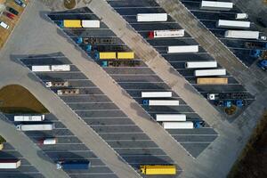 oben Aussicht von Lastwagen auf Parkplatz Menge in der Nähe von logistisch Warenhaus foto