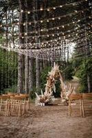 Hochzeitszeremoniebereich mit getrockneten Blumen in einer Wiese in einem Kiefernwald foto