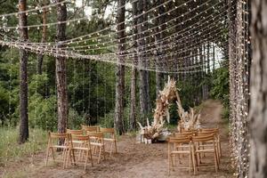 Hochzeitszeremoniebereich mit getrockneten Blumen in einer Wiese in einem Kiefernwald foto