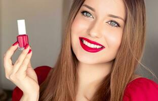 Schönheit Produkt, bilden und Kosmetika, Gesicht Porträt von schön Frau mit Nagel Polieren, Maniküre und passend rot Lippenstift bilden zum Luxus Kosmetik, Stil und Mode foto
