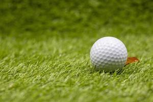 Golfball liegt auf grünem Gras mit Marker foto