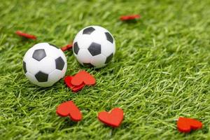Fußball mit rotem Herzen sind auf grünem Gras foto