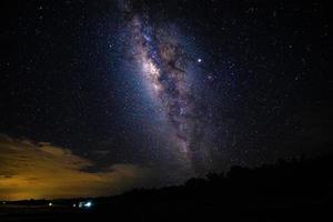 Nachtlandschaft mit der Milchstraße und Licht von zu Hause in den Bergen in Thailand foto