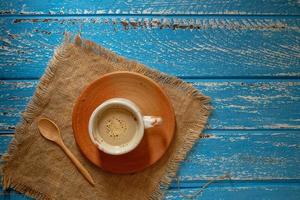 Tasse heißen Kaffee am Morgen auf einem blauen ländlichen Holztisch foto