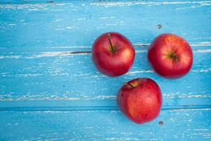 rote Äpfel auf einem Holztischhintergrund foto