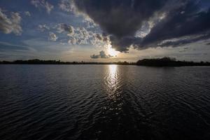 bunter dramatischer Himmel mit Wolken auf dem Fluss unter dem Sonnenuntergang foto