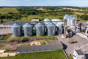 Agro-Verarbeitung und Herstellung Pflanze zum wird bearbeitet und Silber Silos zum Trocknen Reinigung und Lager von landwirtschaftlich Produkte, Mehl, Getreide und Getreide. Antenne Aussicht auf Getreidespeicher Aufzug foto