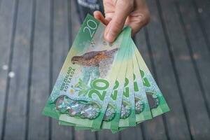 abgeschnitten Schuss Aussicht von jemand zeigen 20 Dollar von Neu Neuseeland Geld. foto
