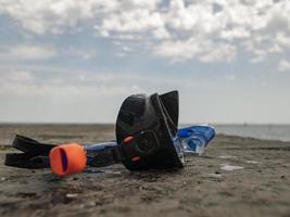 schwarze Taucherbrille und Schnorchel auf einem Betonpier vor dem Hintergrund von blauem Himmel und Wolken foto