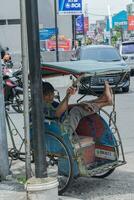 ein Rikscha Abzieher ruhen auf seine Rikscha beim jalan kh zaenal mustafa Tasikmalaya, Indonesien. Tasikmalaya, April 15, 2023 foto