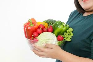 Fett asiatisch Frau halten ein Schüssel von frisch organisch Gemüse Essen zum gut Gesundheit. das Konzept von verlieren Gewicht, reduzieren Fett gesund Essen, Ernährung, Rezept Lebensmittel. Weiß Hintergrund foto