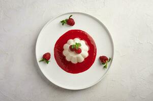 Panna Cotta mit Himbeere Sirup, Pistazien, Beeren und Minze foto