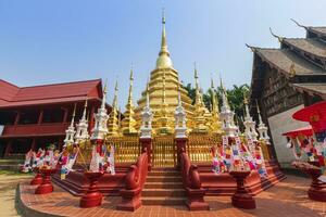 Gebetsfahnen Tung hängen mit Regenschirm oder nördlicher traditioneller Flagge hängen an der Sandpagode im Phantao-Tempel für das Songkran-Festival wird an einem traditionellen Neujahrstag in Chiang Mai, Thailand, gefeiert foto