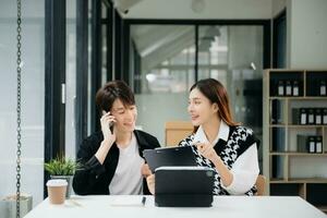 zwei asiatisch Geschäftsfrau und Mann diskutieren Investition Projekt Arbeiten und Planung Strategie mit Tablette Laptop Computer im Büro. foto