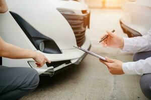 Frau und Versicherung Agent Ansprüche Prozess nach Auto Absturz. mit ein asiatisch männlich Versicherung Einsteller foto