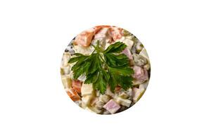 köstlicher frischer oliviersalat mit wurst, ei, gurke, grünen erbsen, karotten und mayonnaise foto