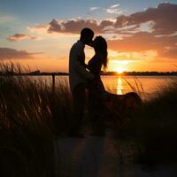 Paar Teilen ein Kuss im Vorderseite von Sonnenuntergang foto