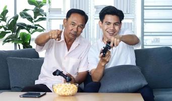 Vater und Sohn spielen im Urlaub glücklich zu Hause Videospiele foto