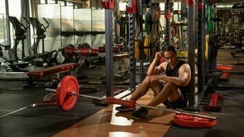 voll Körper Porträt von müde sportlich männlich nach Workouts auf Leistung Übung Maschine im ein Fitnessstudio Verein. foto