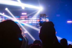 Menschen halten Clever Telefon und Aufzeichnung und Fotografieren im Konzert , Silhouette von Hände mit Handy, Mobiltelefon , Veranstaltung Hintergrund Konzept foto