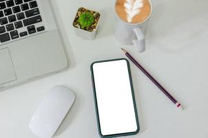 Draufsicht Mock-up Smartphone weißer leerer Bildschirm und Bleistift Kaffeetasse Maus Computer Laptop flach auf Schreibtisch legen foto