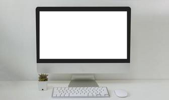 Computer-Desktop-Mock-up und Mauskaktus weißer leerer Bildschirm auf dem Tisch. verwendet, um Text auf dem Computerbildschirm zu bewerben foto