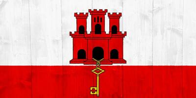 Gibraltar-Flagge auf einem strukturierten Hintergrund. Konzept-Collage. foto