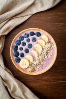 Joghurt- oder Smoothie-Bowl mit Blaubeere, Banane und Müsli – gesunder Ernährungsstil foto