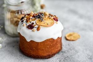 festliche Kuchen mit weißer Glasur, Nüssen und Rosinen mit Ostereiern auf dem festlichen Tisch foto