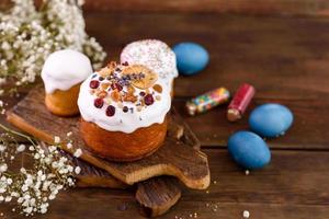 festliche Kuchen mit weißer Glasur, Nüssen und Rosinen mit Ostereiern auf dem festlichen Tisch foto