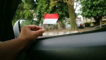 das indonesisch Flagge ist montiert auf das Windschutzscheibe von das Auto zu herzlich willkommen Indonesiens Unabhängigkeit Tag foto