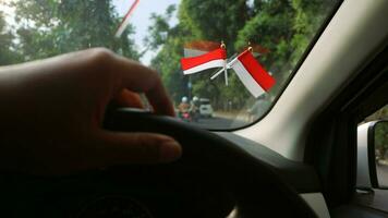 das indonesisch Flagge ist montiert auf das Windschutzscheibe von das Auto zu herzlich willkommen Indonesiens Unabhängigkeit Tag foto