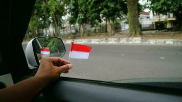 Hand halten indonesisch Flagge im das Auto zu herzlich willkommen Indonesiens Unabhängigkeit Tag foto