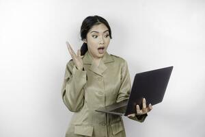 schockiert Regierung Arbeiter Frau halten ihr Laptop mit ihr Mund breit offen. pns tragen khaki Uniform. foto