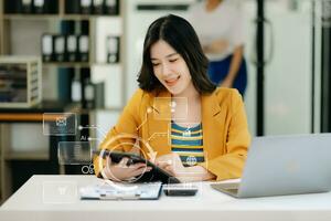 Geschäftsfrau, die mit Smartphone und Laptop und digitalem Tablet-Computer im Büro mit digitalen Marketingmedien im virtuellen Symbol arbeitet foto