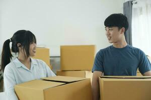 asiatisch jung glücklich Neu verheiratet Paar ziehen um zu ihr Neu Haus oder echt Anwesen. foto